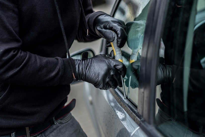 Car thief trying to break into vehicle with a screwdriver.