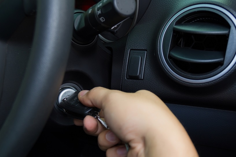 Person inserting car keys into vehicles ignition.